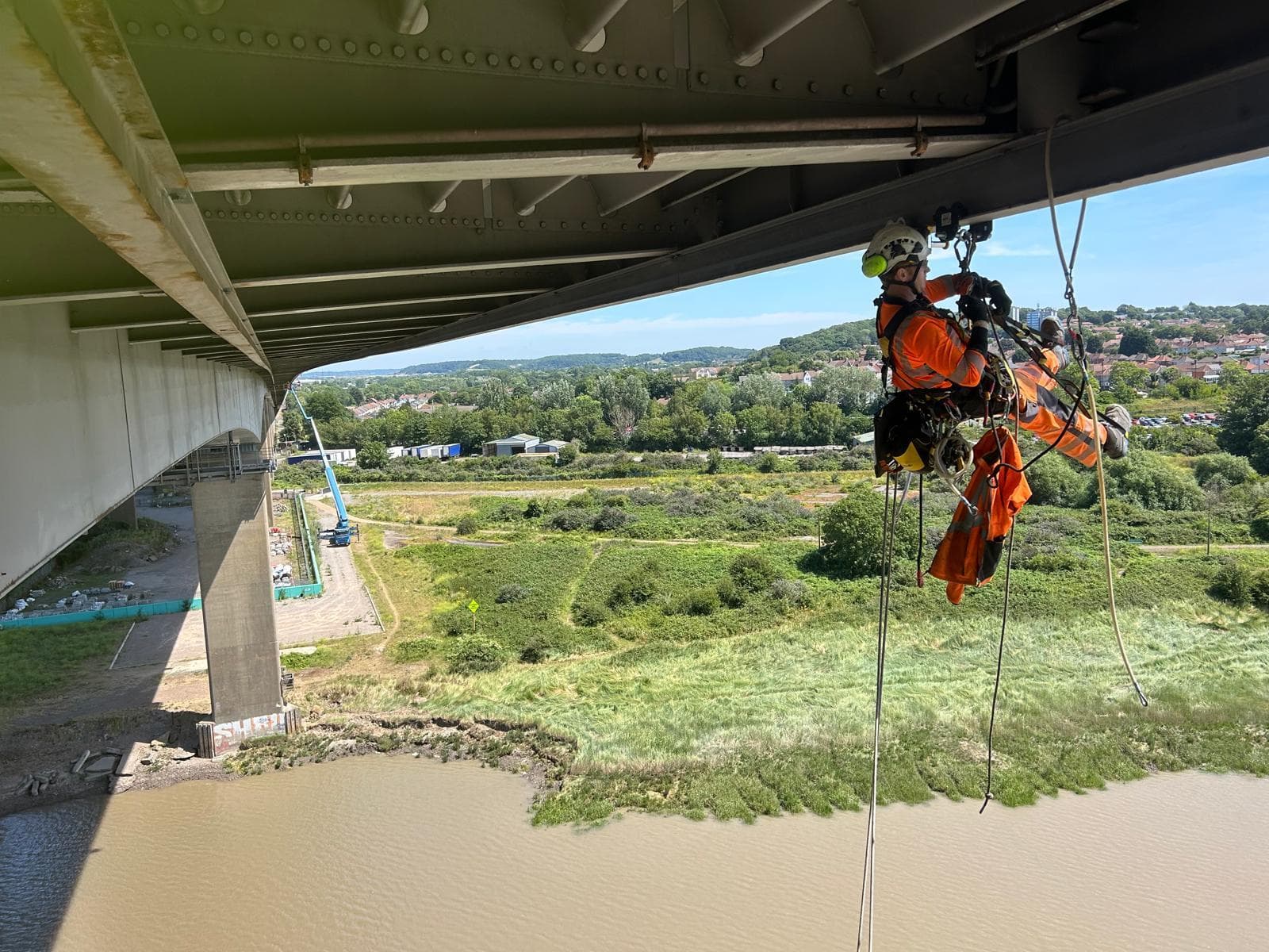 Rope access inspector working beneath the M5 Avonmouth Viaduct above the River Avon